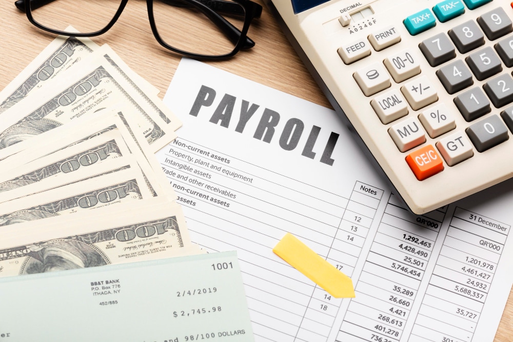 Money and payroll information on a desk.