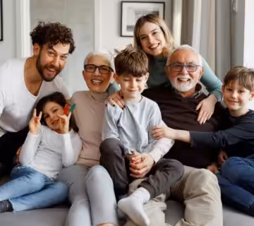 Multigenerational family smiling together at home, highlighting the importance of estate planning to protect loved ones and their future 
