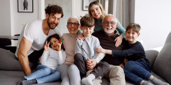 Multigenerational family smiling together at home, highlighting the importance of estate planning to protect loved ones and their future.